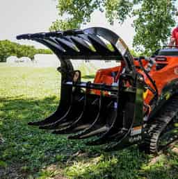 40-inch heavy-duty grapple bucket attached to a compact Kubota loader, showing curved tines and reinforced frame for material handling and debris pickup