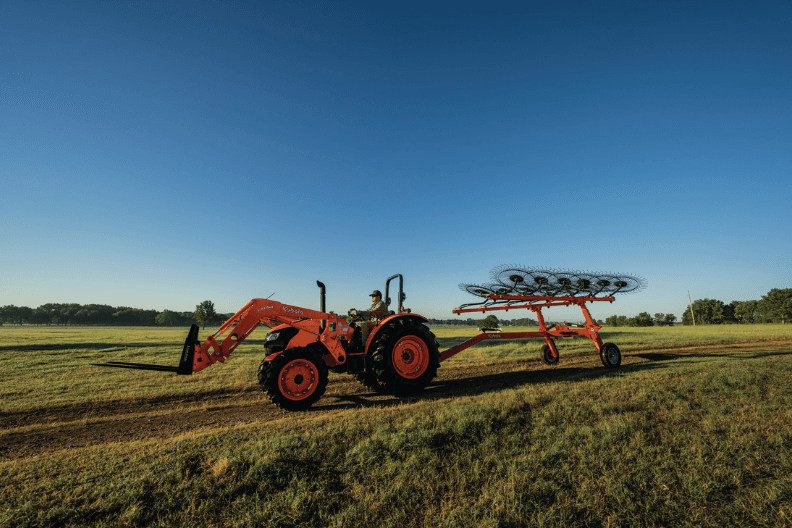 Tractor moving down trail with implement