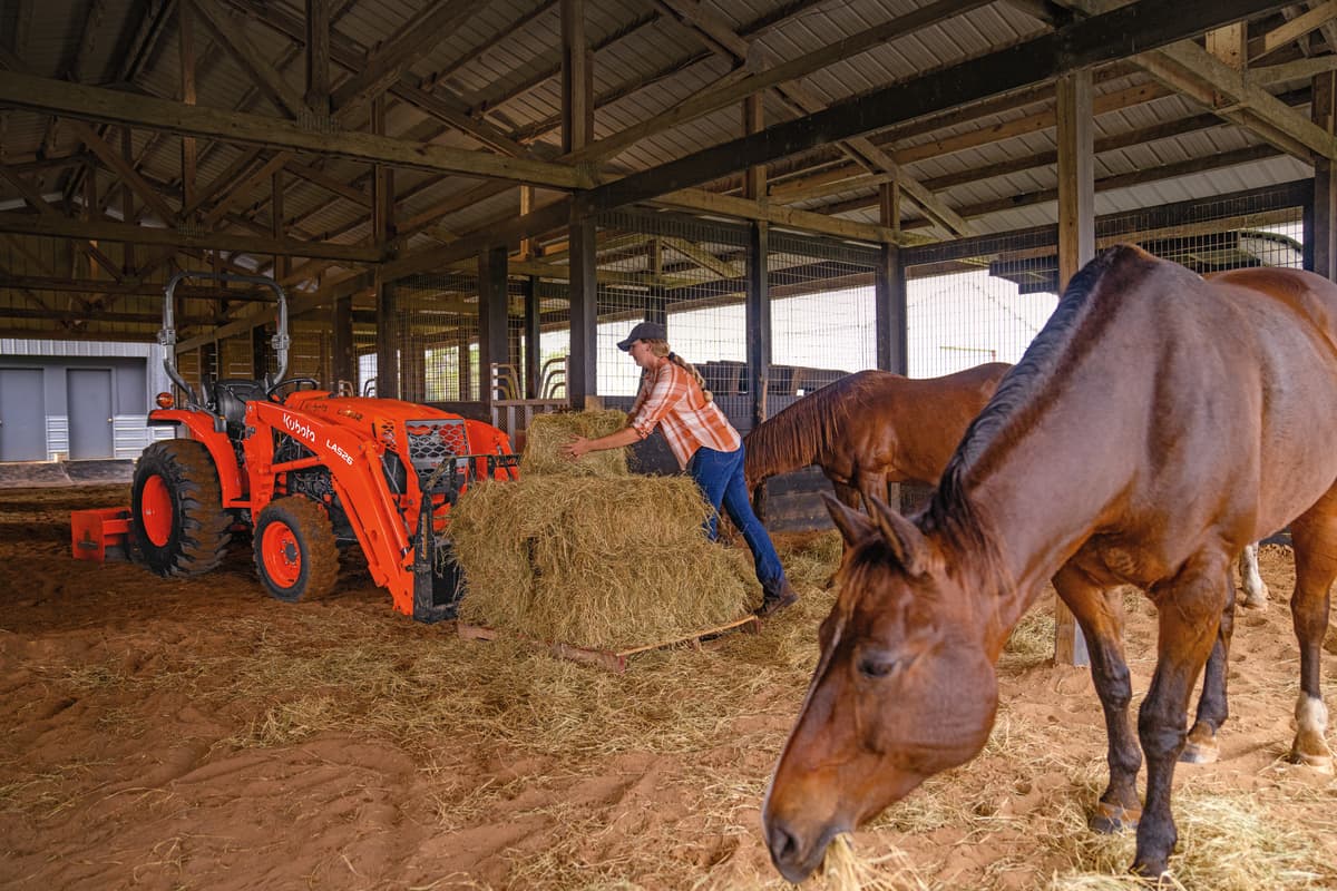 Kubota L2502 being used to carry hay bales to horses