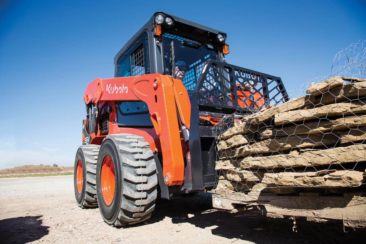 Kubota SSV75 lifting a pallet of stone
